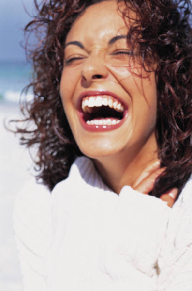 lady curly hair smiling wearing white.