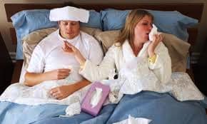 people sick in bed with tissues.
